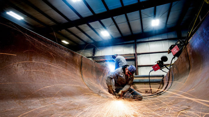 A welder at work deep inside the half round body of a dump semitipper.