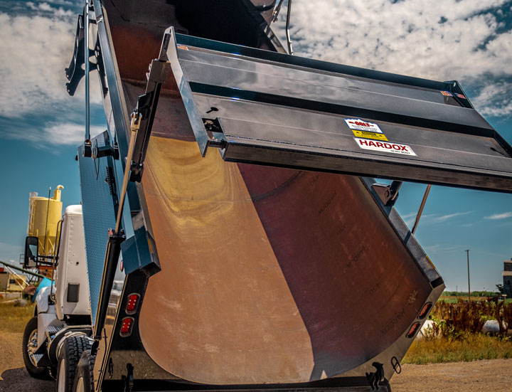 An elliptical-style dump truck body made in Hardox 500 Tuf that is ready for dumping.