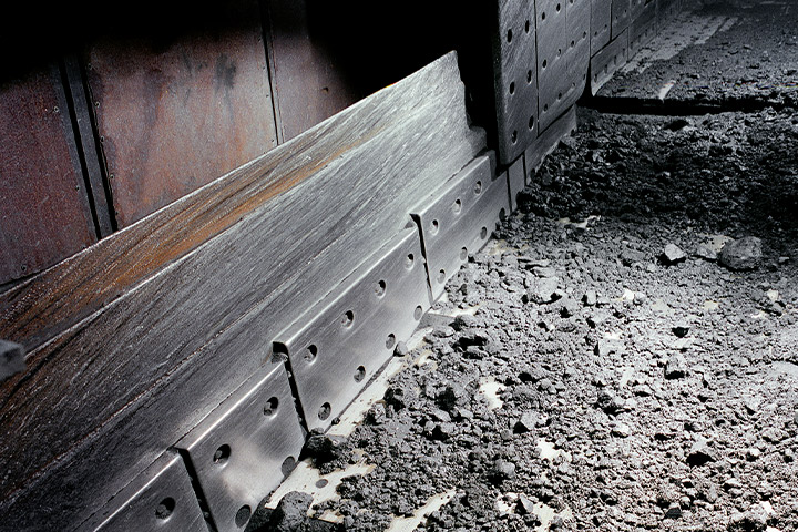 Interior of mining equipment with abrasive rocks lying on a liner made in Hardox® steel