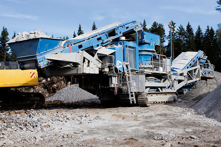 Blue mining equipment on site near Scandanavian forests